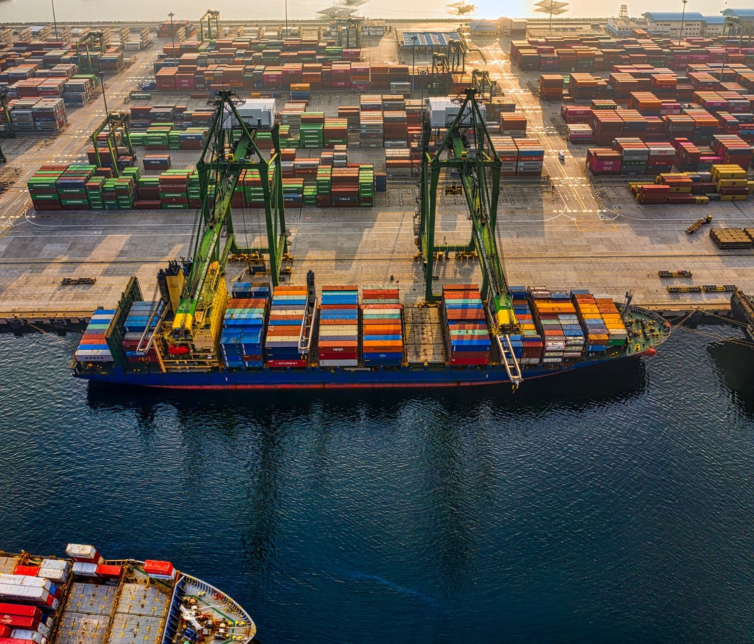 Aerial view of shipping containers stacked at a port terminal.